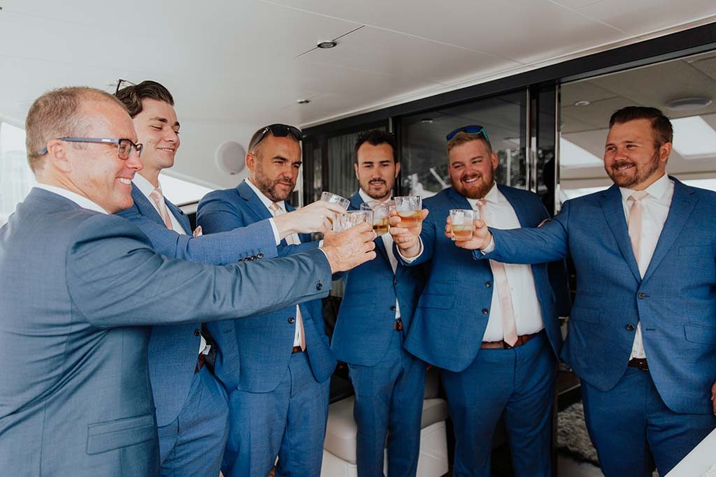 groom with groomsmen drink and cheers