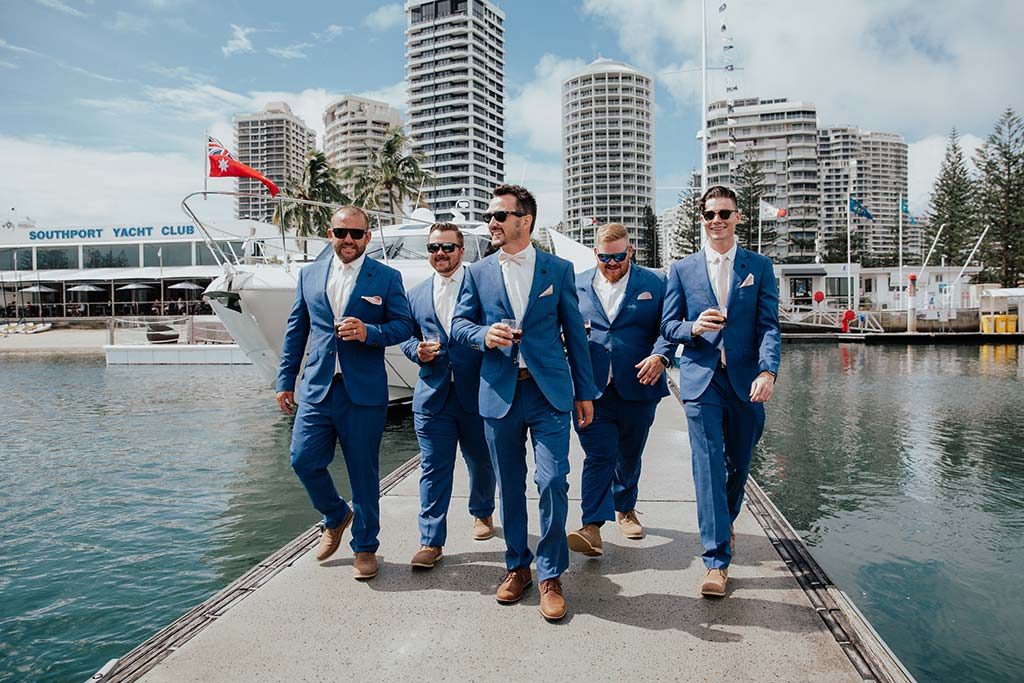 Groom walking with groomsmen before wedding