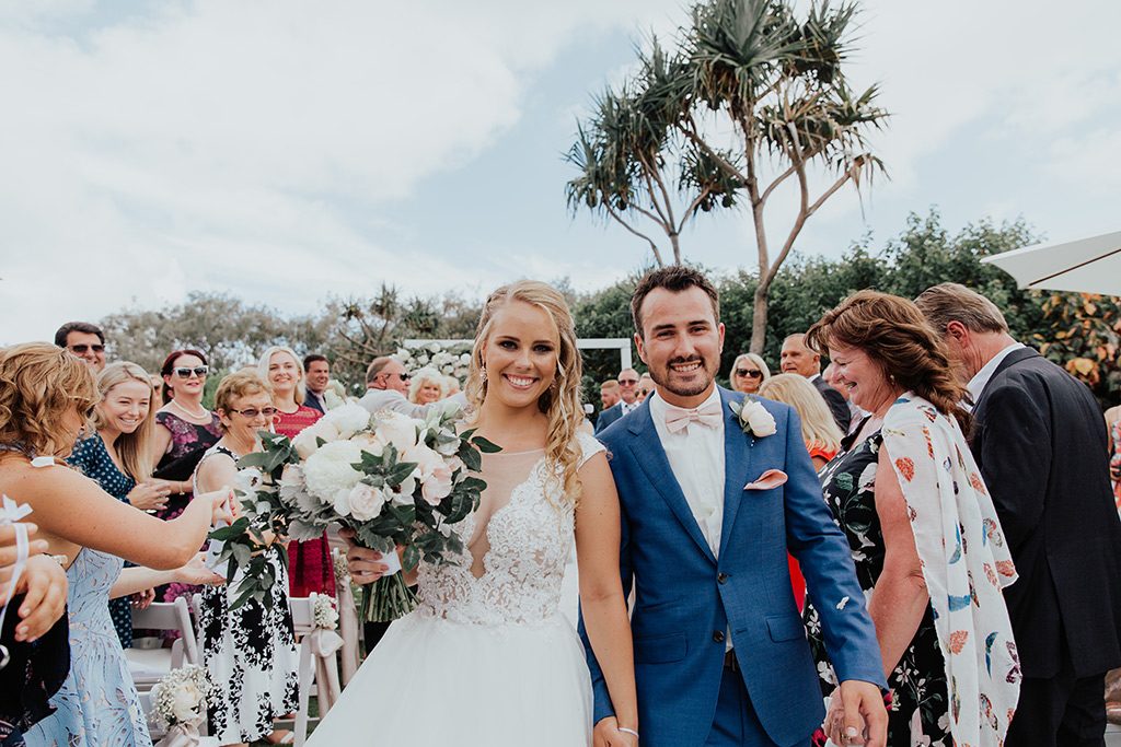 bride and groom walk down isle