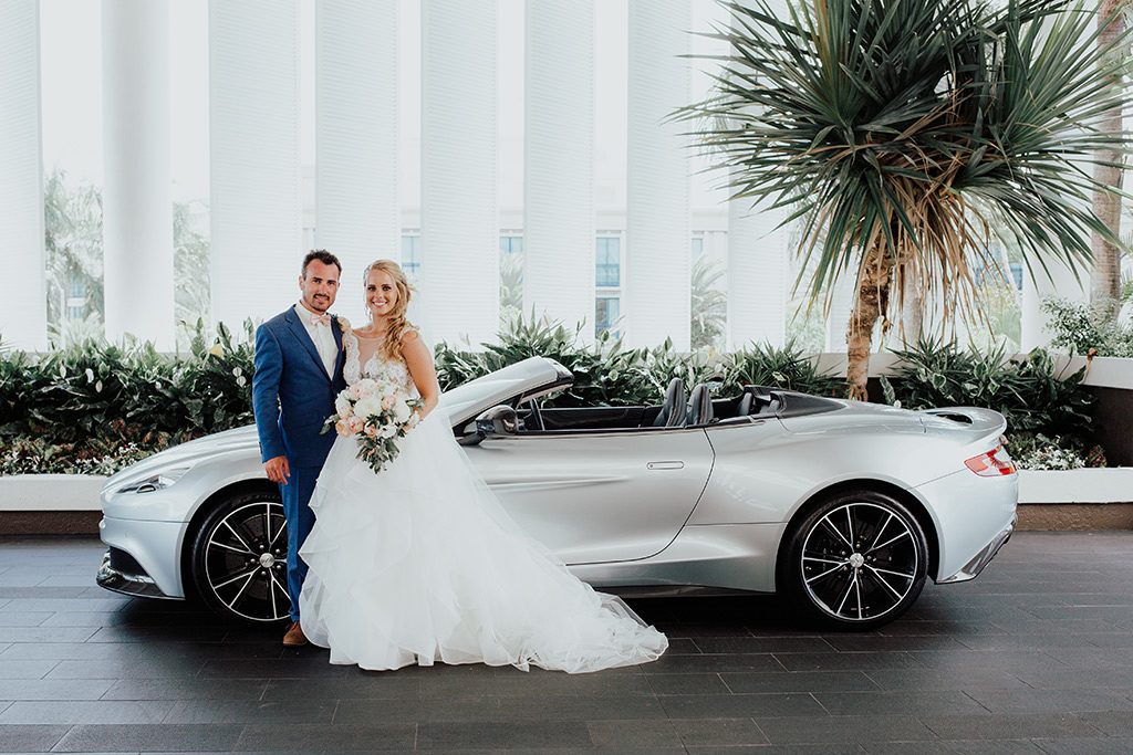 bride and groom with car