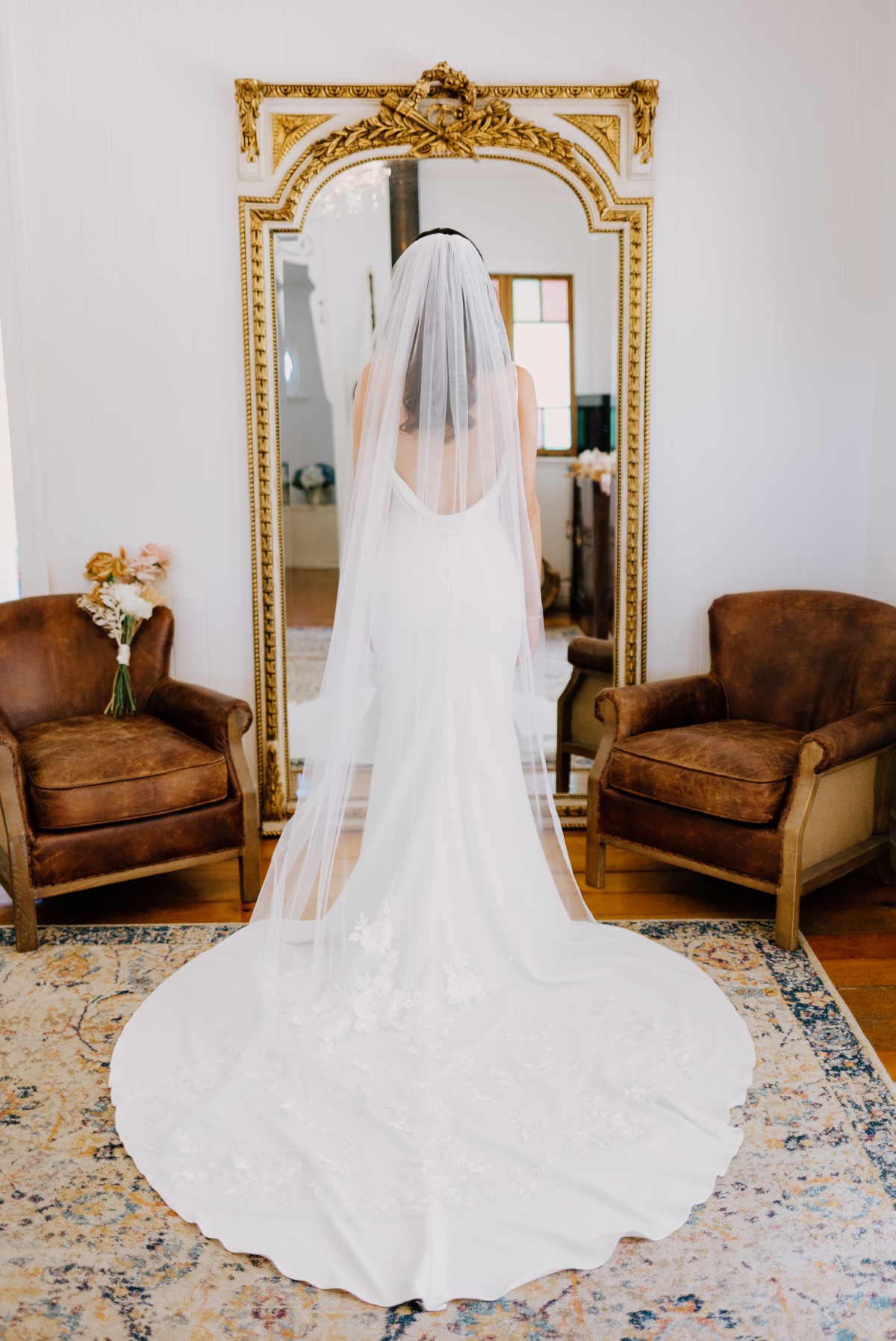 Bride in wedding dress looking in mirror