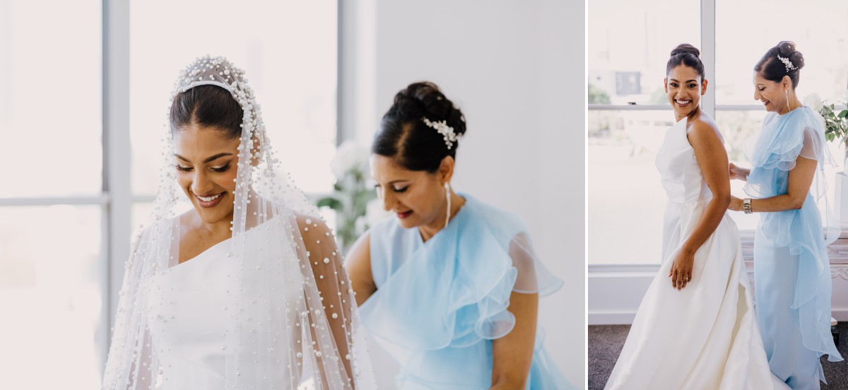 bride helping her daughter into her wedding dress