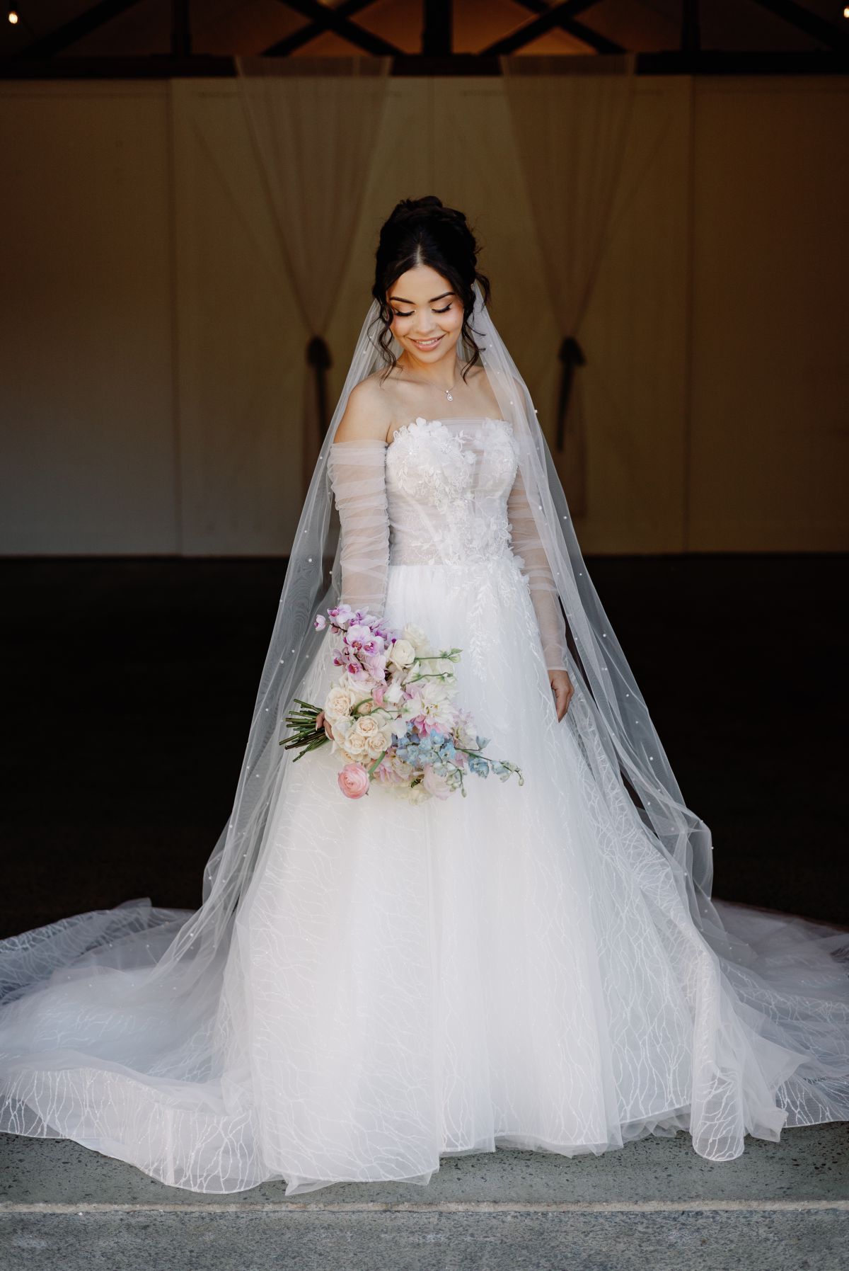 Wedding portrait of bride looking at her flowers