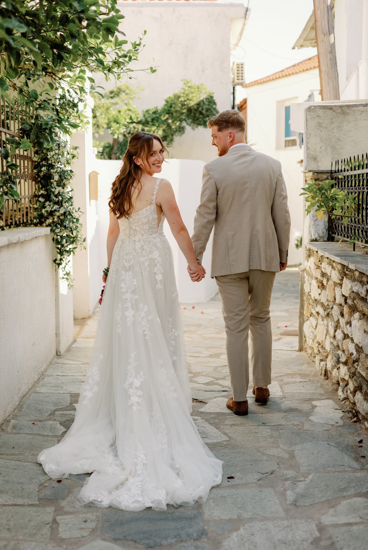Bride and groom walking hand in hand in Skiathos